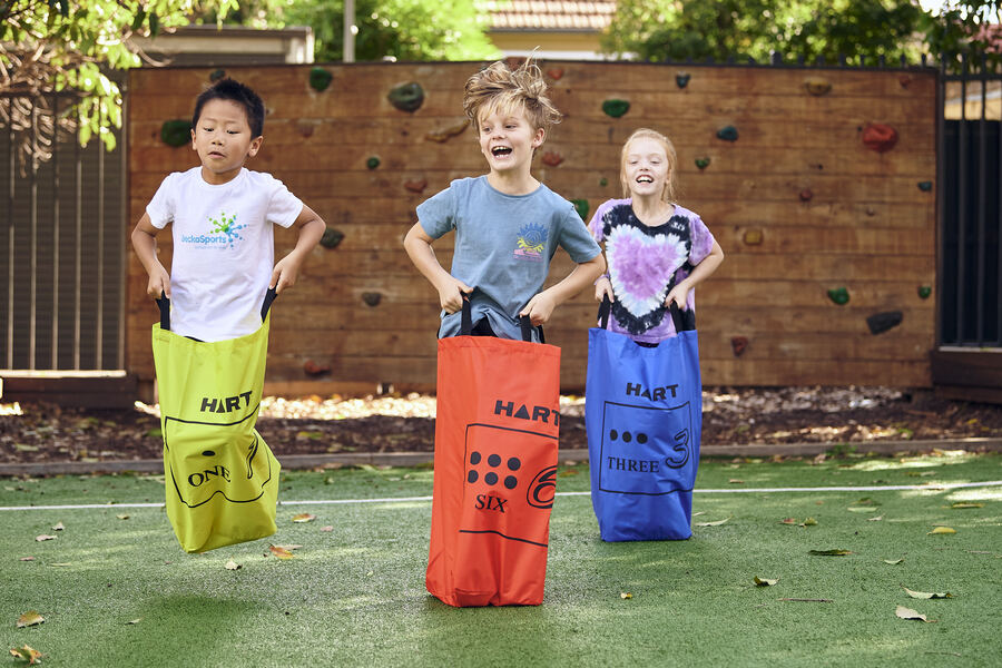 Kids taking part in a sack race at a school fete with GeckoSports